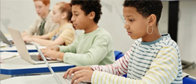 一名男孩使用笔记本电脑的特写。