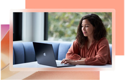 A woman sitting at a table using a laptop.