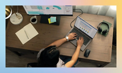 A person sitting at a desk using a laptop.