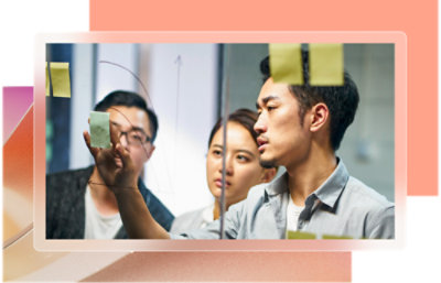 A group of people looking at a glass board.