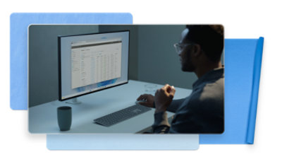 Een man die aan een bureau zit en naar een computerscherm kijkt.