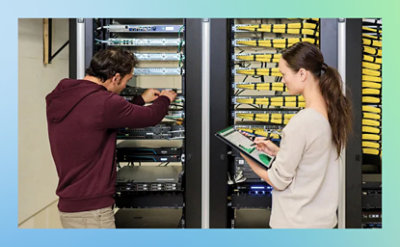 A person and and another person working in a server room