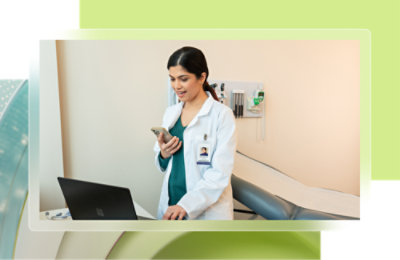 A woman in a white coat using a laptop.
