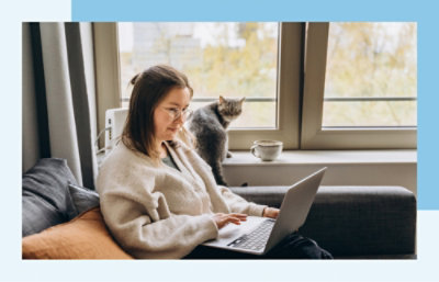 A woman sitting on a couch using a laptop.