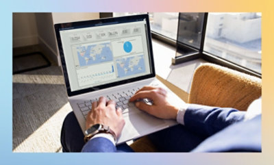 Person analyzing data on a laptop with graphs and charts on the screen.