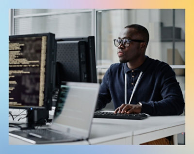 Person working on a computer with multiple monitors in an office setting.