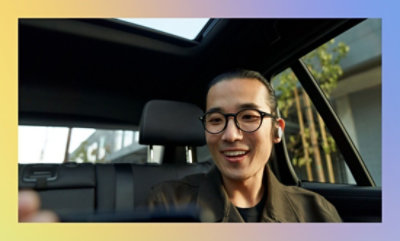 Person sitting in the driver's seat of a car with an open sunroof.