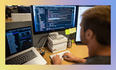 Un homme utilisant un ordinateur avec un écran étendu.