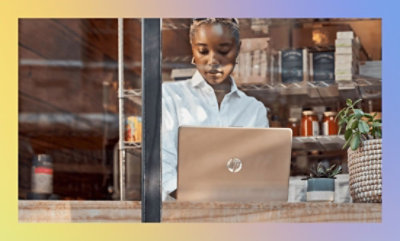 Une femme assise à un bureau regardant un ordinateur portable.