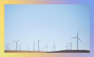 A landscape with multiple wind turbines under a clear blue sky.