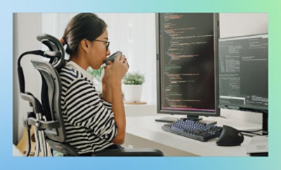 机に座り、カップで飲み物を飲んでいる人