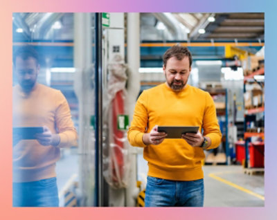 A man in a yellow shirt holding a tablet.