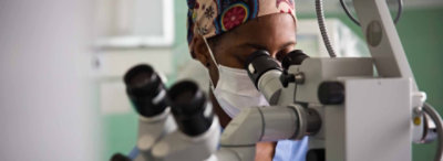 A medical professional using a microscope.