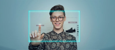 A person wearing glasses and touching a screen