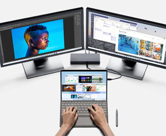 A person uses two external monitors to edit content with a Surface Pro 8.