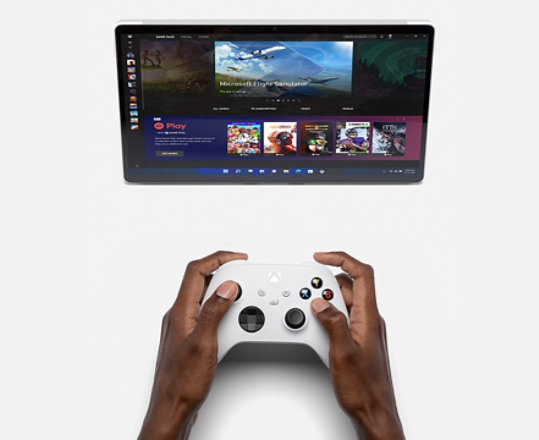 A person uses an xbox consul to play a game on a Surface Pro 8.