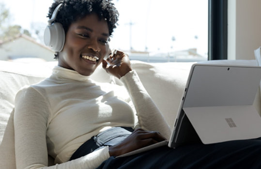 A person uses Surface Headphones and Surface Pro 8 to connect.
