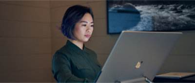 A woman with short dark hair looking at a computer.