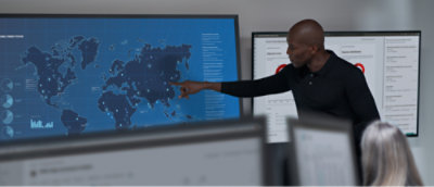 A man in a black shirt pointing at a map.