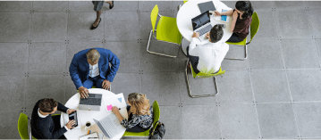 Eine Luftaufnahme von Personen bei der Arbeit an Tischen in einer Cafeteria