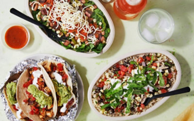 Two burrito bowls and a plate of tacos