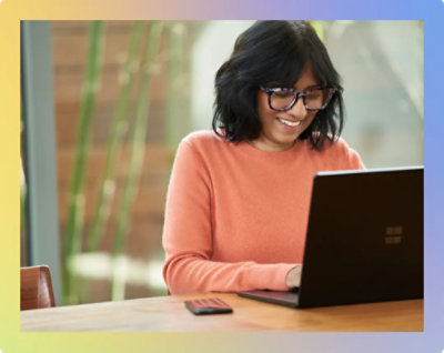 A person in glasses smiling at a computer