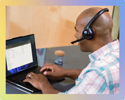 A person wearing a headset and using a computer