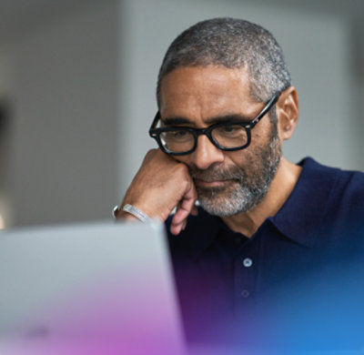 Woman with glasses types on a laptop