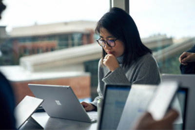A person sitting at a desk using a laptop.