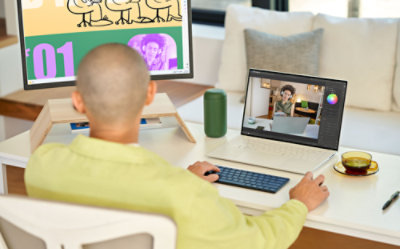 Person working at a desk with a laptop and monitor.