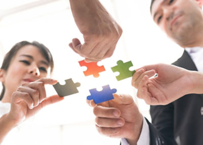 A hand holding a piece of a puzzle.