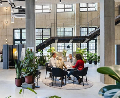 A group of people sitting around a table in an office.