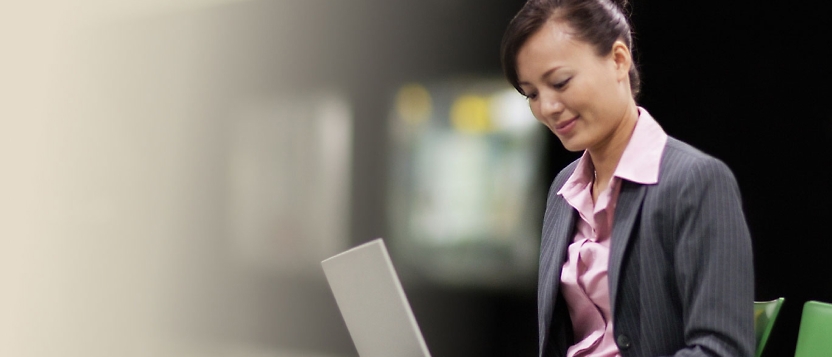 A woman in a business suit using a laptop.