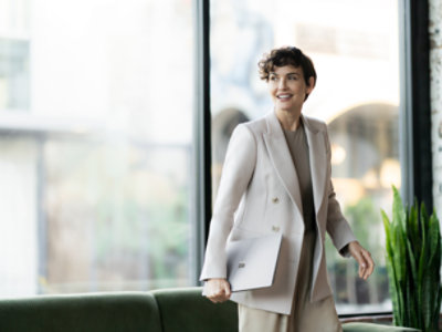 A person in a suit holding a computer
