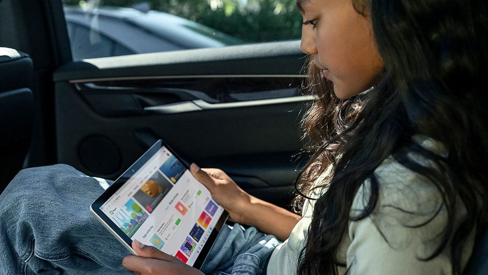 เด็กคนหนึ่งกำลังใช้ Surface Go 3 เป็นแท็บเล็ตในรถยนต์