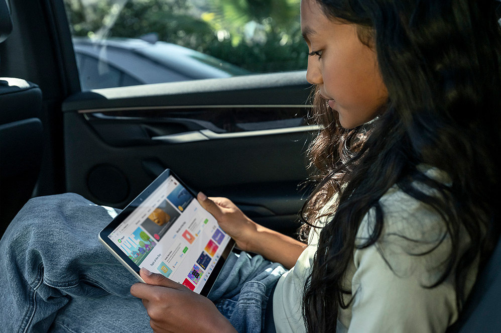 Et barn, der bruger Surface Go 3 som en tablet i bilen.