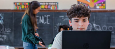 Um menino olhando para um notebook.