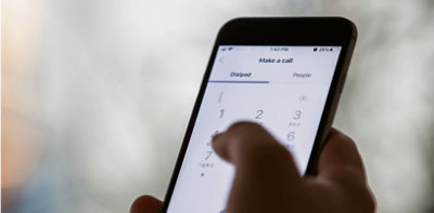 Een hand die een mobiele telefoon vasthoudt en een oproep plaatst op het toetsenblok in Teams