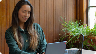 אדם יושב ליד שולחן ומשתמש במחשב נישא