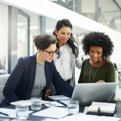 Three women looking at a laptop.