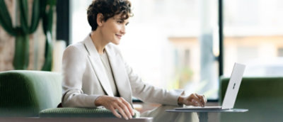 En person i hvit dress som arbeider på en bærbar datamaskin