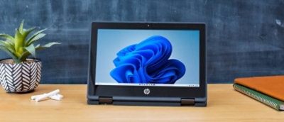 Um notebook sobre uma mesa exibindo um objeto azul na tela.