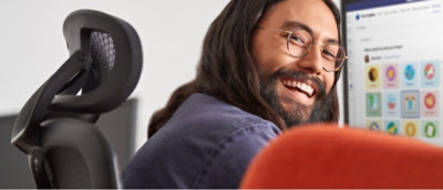 A person with long hair and glasses smiling