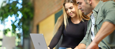A man and woman looking at a laptop.