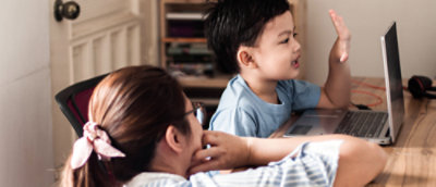 A woman and a child looking at a laptop.
