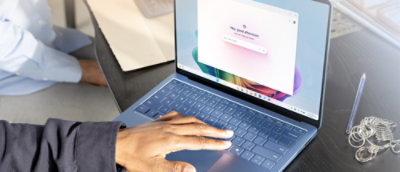 A person's hand typing on a laptop keyboard.