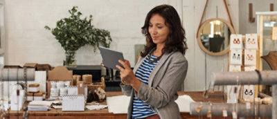 A women smiling while looking at a tablet.