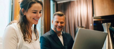 A man and woman looking at a laptop.
