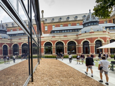 A group of people walking outside of a building