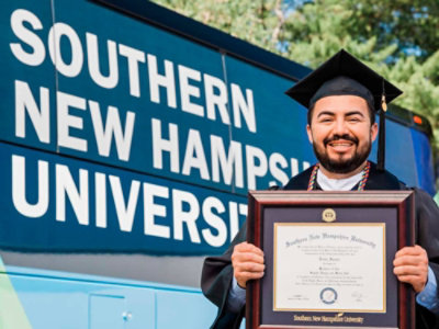 A person in a graduation gown holding a diploma